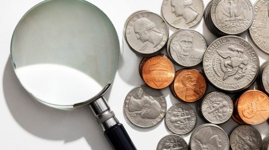 still-life-dollar-coins-with-magnifying-glass_23-2150794345